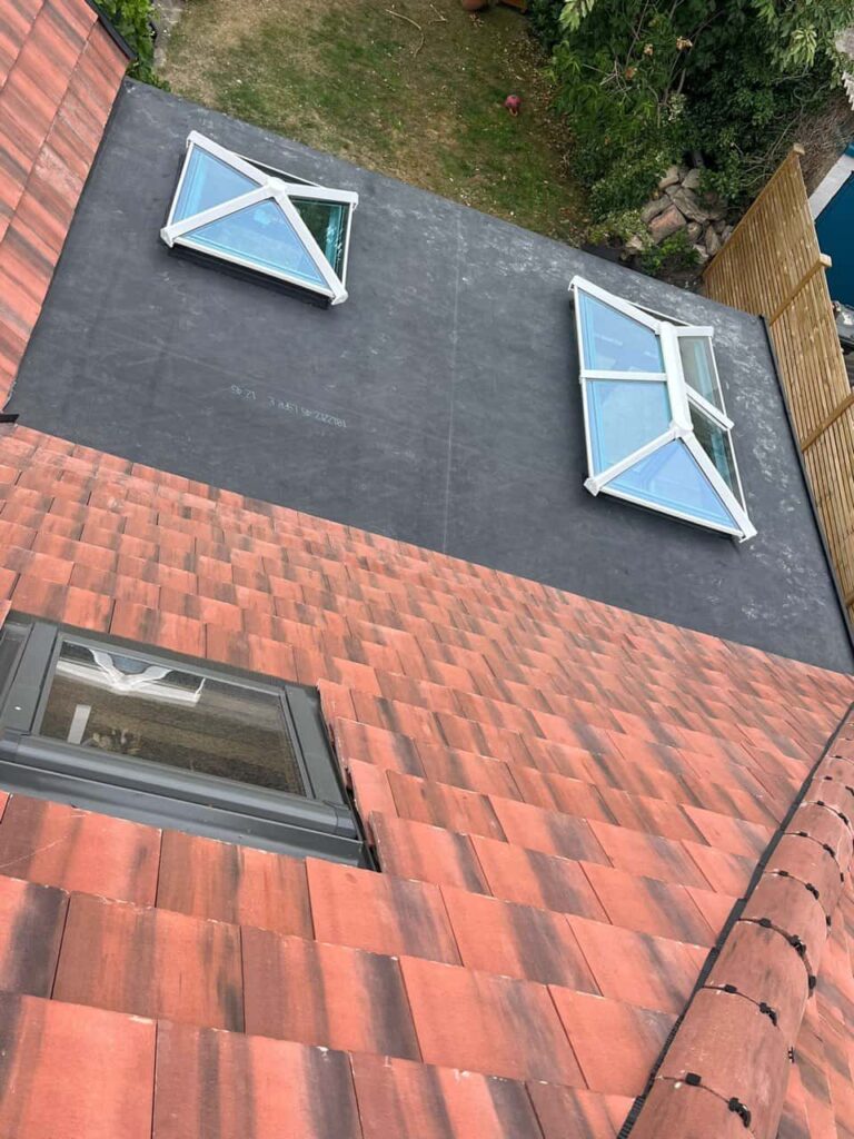 This is a photo taken from the roof ridge looking down a tiled pitched roof on to a flat roof. Works carried out by MCM Roofing Repairs Trowbridge